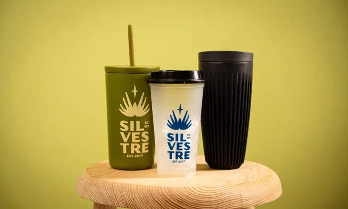 Three Silvestre reusable cups on a wooden stool